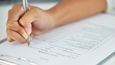 hand writing on a clipboard with a checklist and detailed form information